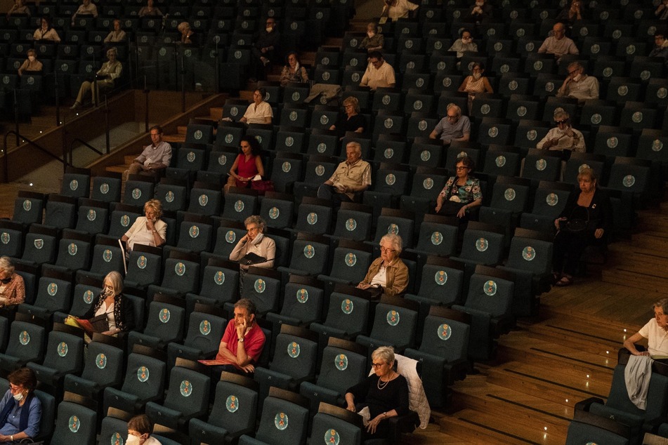 Zuschauer sitzen unter Mindestabstand in einem Theater. (Symbolbild)