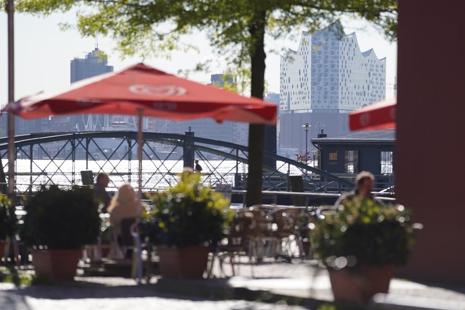 Kunden genießen die Sonne in einem Café am Fischmarkt. Ab dem Wochenende darf auch die Innengastronomie wieder öffnen.