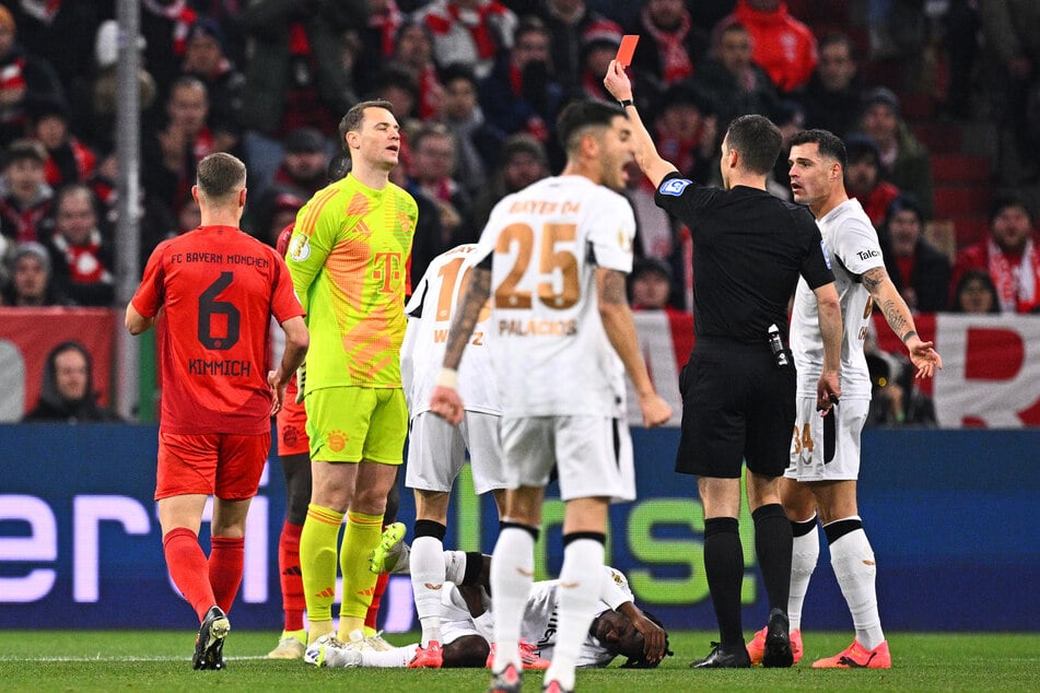 Schiedsrichter Harm Osmers zeigt Bayern-Stammkeeper Manuel Neuer (2.vl) die Rote Karte.