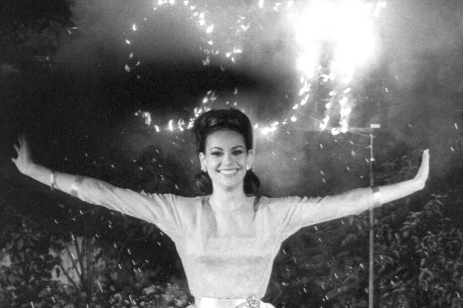 Claudine Auger, Schauspielerin aus Frankreich, posiert vor einem "007" Feuerwerk".