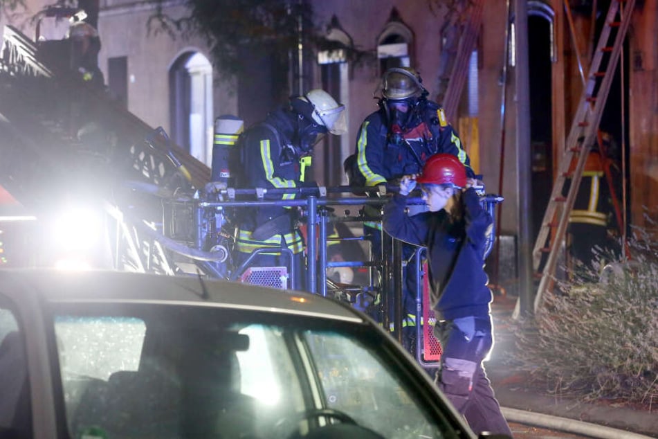 Kameraden besteigen an der Brandstelle einen Löschkorb.