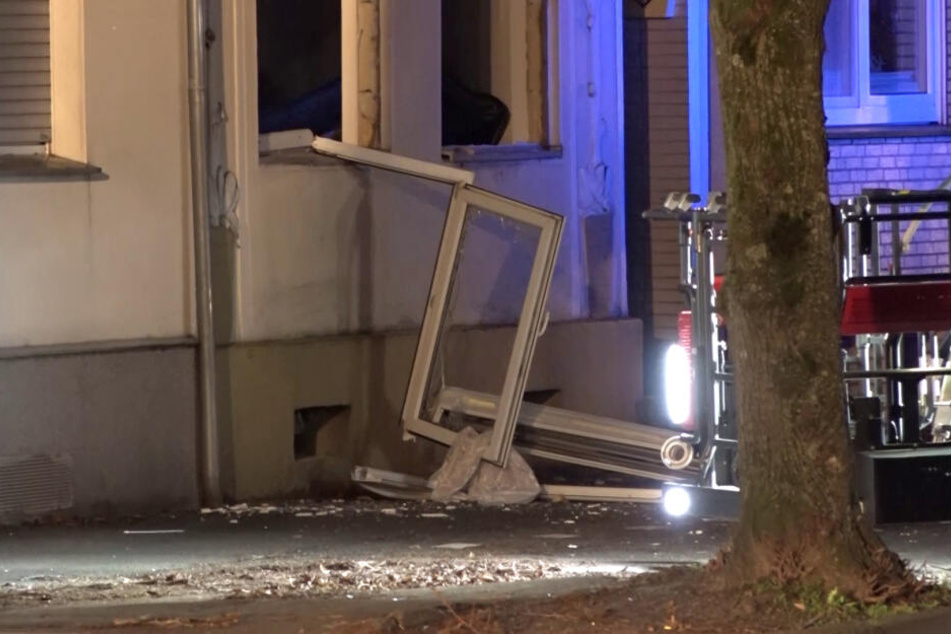 Fenster und Fensterrahmen liegen nach einer Explosion vor einem Haus auf dem Bürgersteig. Die Detonation war so stark, dass Einsatzkräfte das einsturzgefährdete Haus zunächst nicht betreten konnten.