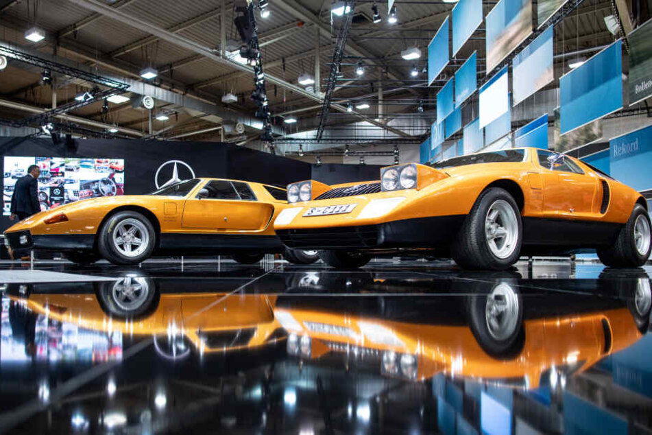 Die beiden Fahrzeuge Mercedes-Benz C111 von 1969 (r) und Mercedes-Benz C111-II von 1970 spiegeln sich bei der Techno Classica für Oldtimer und Youngtimer im Boden.