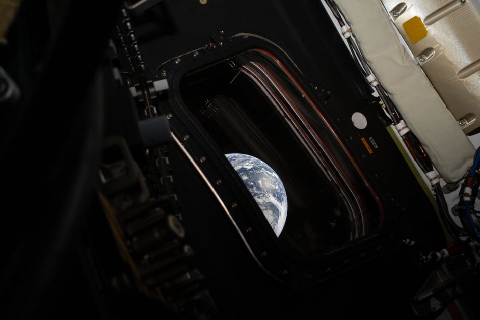 This handout picture provided by NASA shows a view of Earth taken by NASA astronaut and Artemis II commander Reid Wiseman from one of the Orion spacecraft's four main windows after completing the translunar injection burn on Thursday.