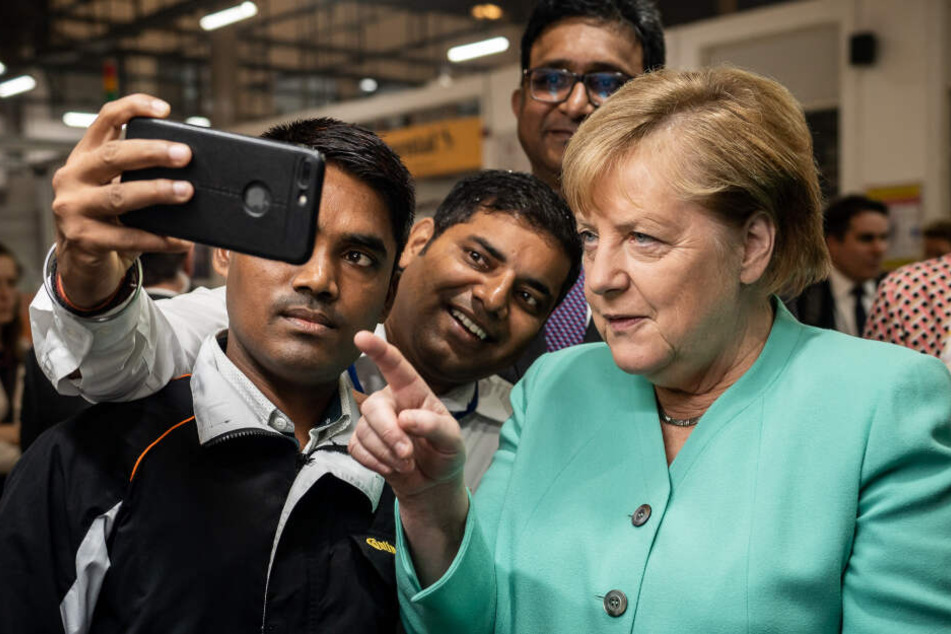 Bundeskanzlerin Angela Merkel (CDU), macht ein Selfie mit Mitarbeitern beim Besuch der Continental Automotive Components India.