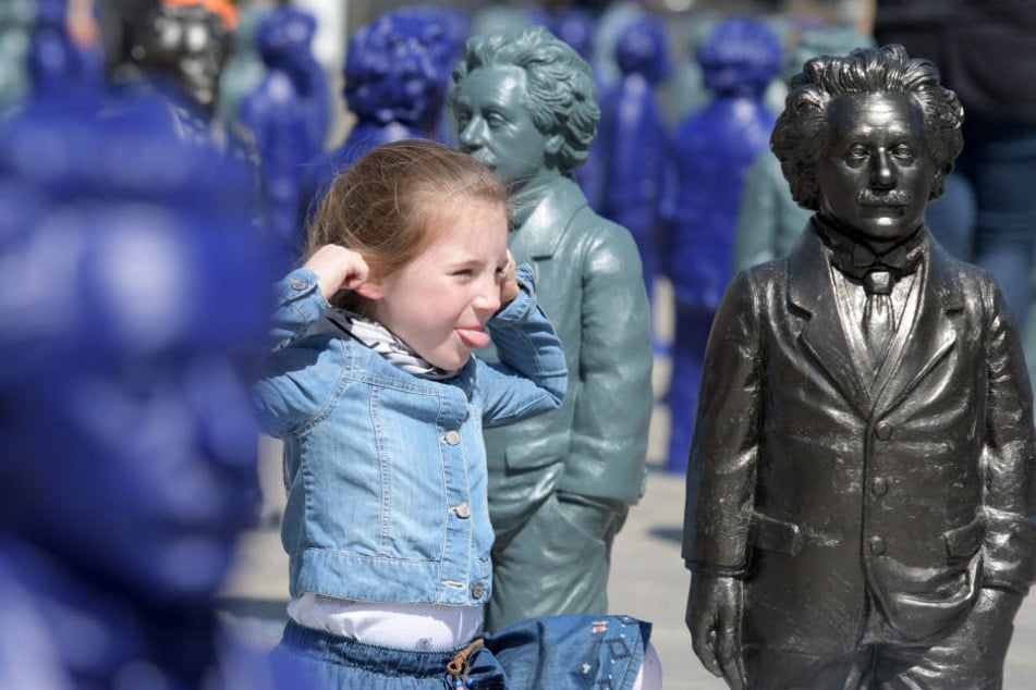 Auf dem Münsterplatz streckt die sechs Jahre alte Isabell Miniaturdarstellungen von Albert Einstein die Zunge heraus.