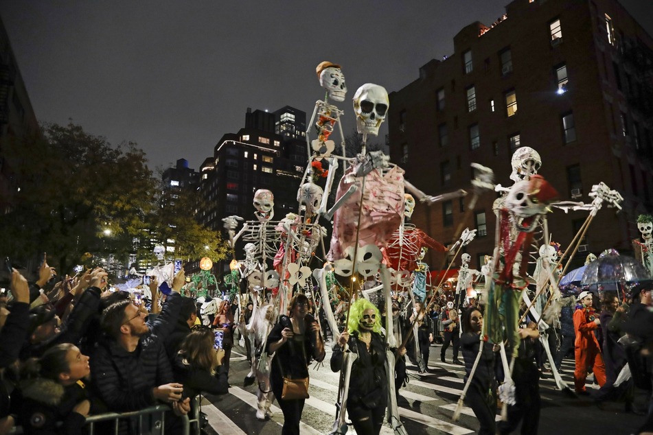 Menschen mit Skelett-Figuren marschieren während der Greenwich Village Halloween-Parade.
