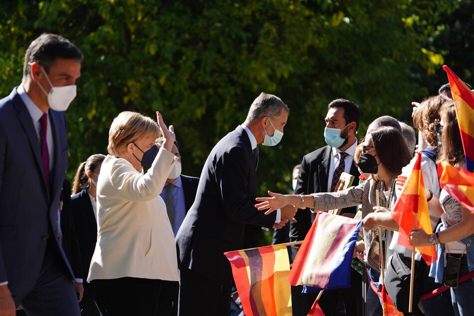 Pedro Sanchez (l-r), Ministerpräsident von Spanien, Angela Merkel und König Felipe VI. begrüßen Schaulustige bei ihrer Ankunft im Kloster von Yuste.