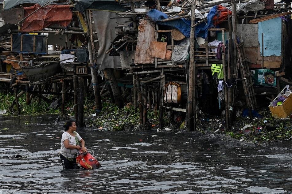 A woman collects plastic at Baseco in Manila on July 26, 2023.
