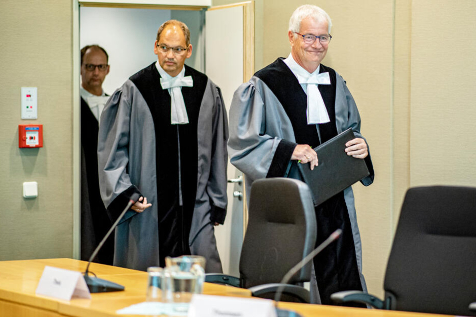 Die Richter Bernhard Flor (von rechts nach links), Christof Brüning und Felix Welti betreten den Gerichtssaal des Landesverfassungsgerichts.