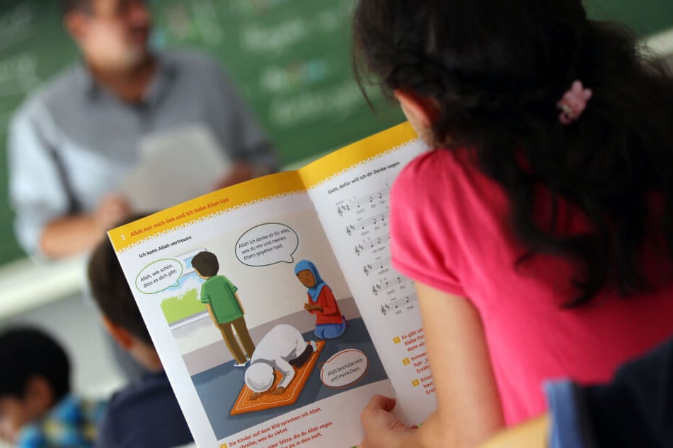 Ein Mädchen liest in einer Schule während des islamischen Religionsunterrichts in einem Schulbuch.