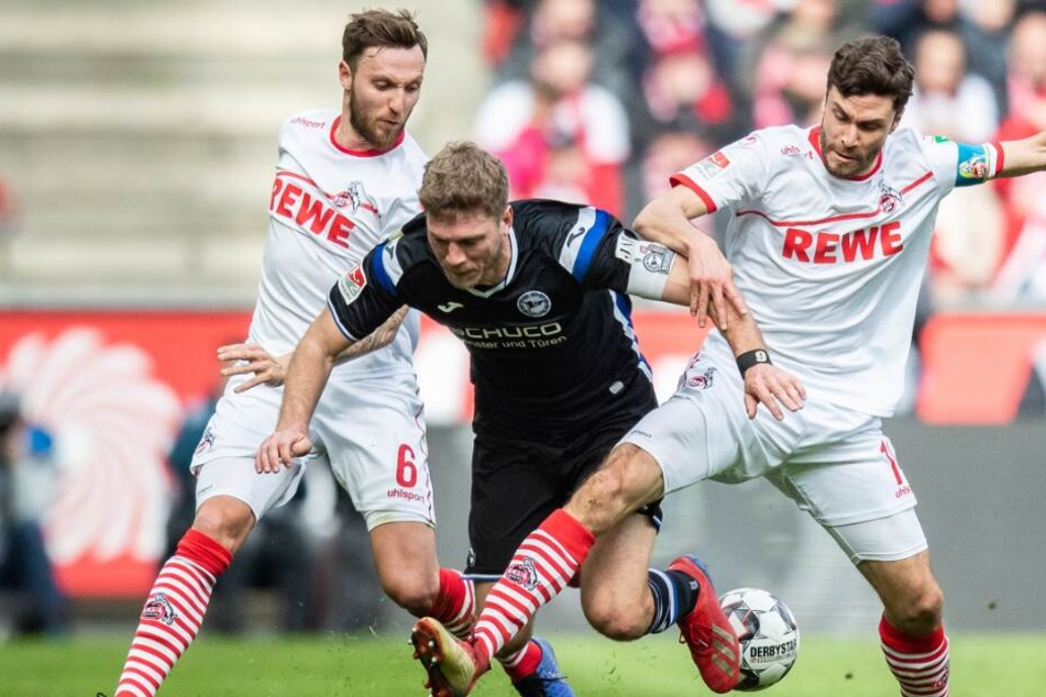 Kölns Marco Höger (l) und Kölns Jonas Hector (r) im Kampf um den Ball mit Bielefelds Fabian Klos.