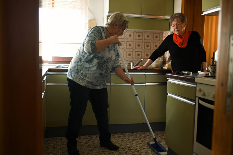 Birgit Bechler (L) hilft der 85-jährigen Frau Fug bei der Hausarbeit.