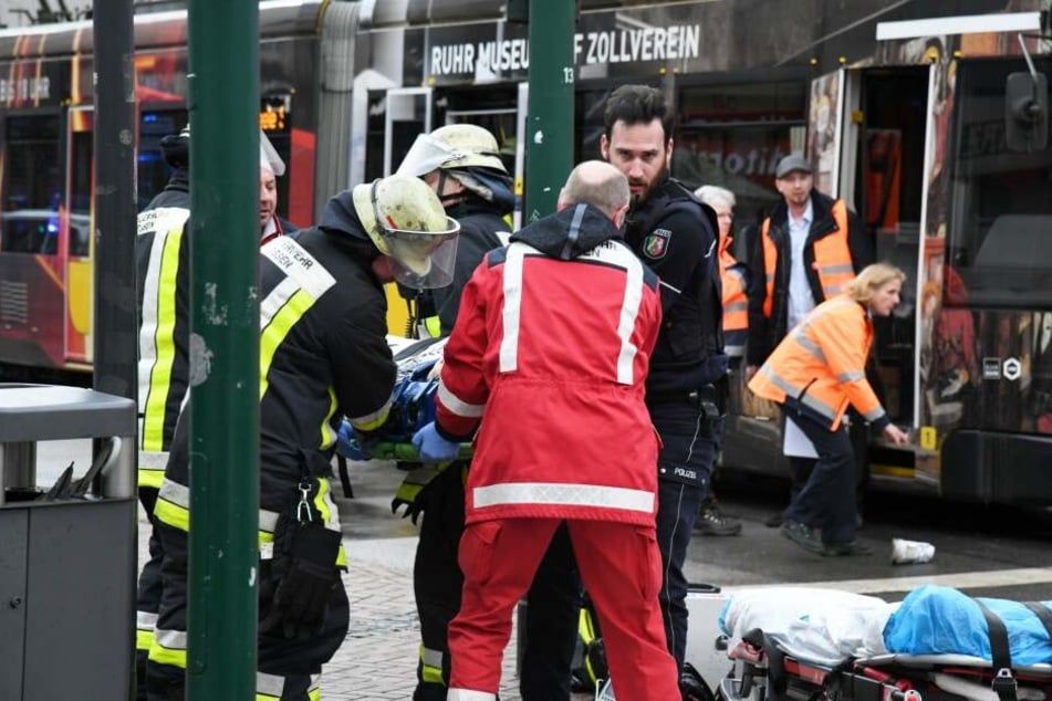 Einsatzkräfte versorgen Verletzte, nachdem eine Seniorin an einer Straßenbahn-Haltestelle in eine Menschenmenge gefahren war.