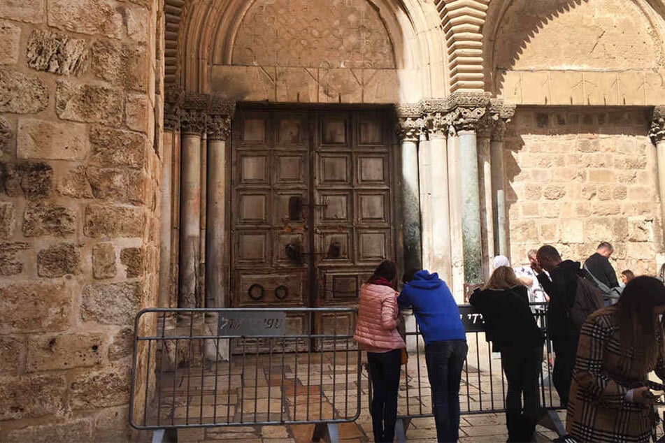 Touristen stehen am 25. Februar 2018 vor der verschlossenen Grabeskirche in Jerusalem.