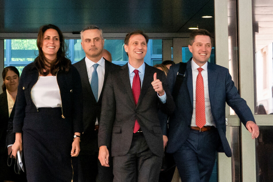 John Poulos (2nd from l.), CEO of Dominion Voting Systems, and lawyers Davida Brook (l.), Justin Nelson, and Stephen Shackleford leave the courthouse in Wimington, Delaware.