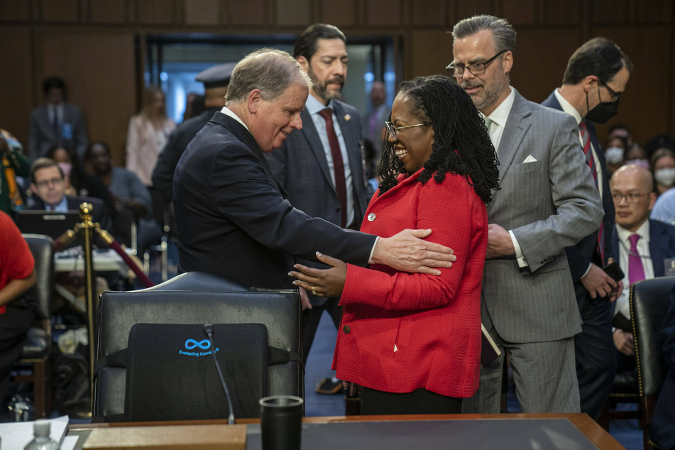 White House liaison and former Alabama Senator Doug Jones greets Jackson at the confirmation hearing.