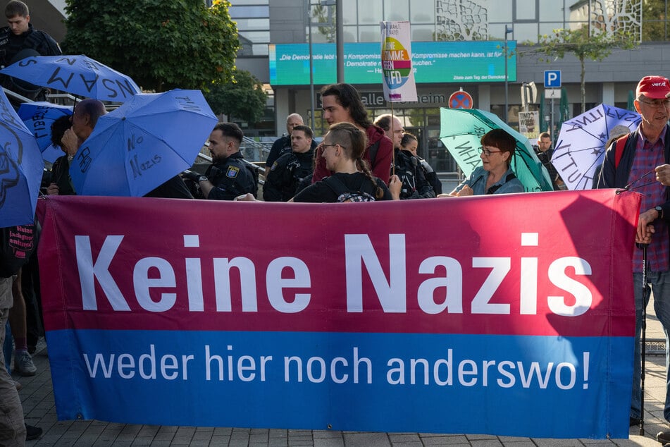 "Keine Nazis - weder hier noch anderswo!" steht auf einem Banner von Demonstranten, die gegen den Landesparteitag der hessischen AfD protestieren.