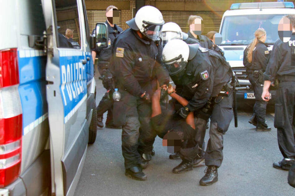 Einer der Demonstranten wird von vier Polizisten in Gewahrsam genommen.