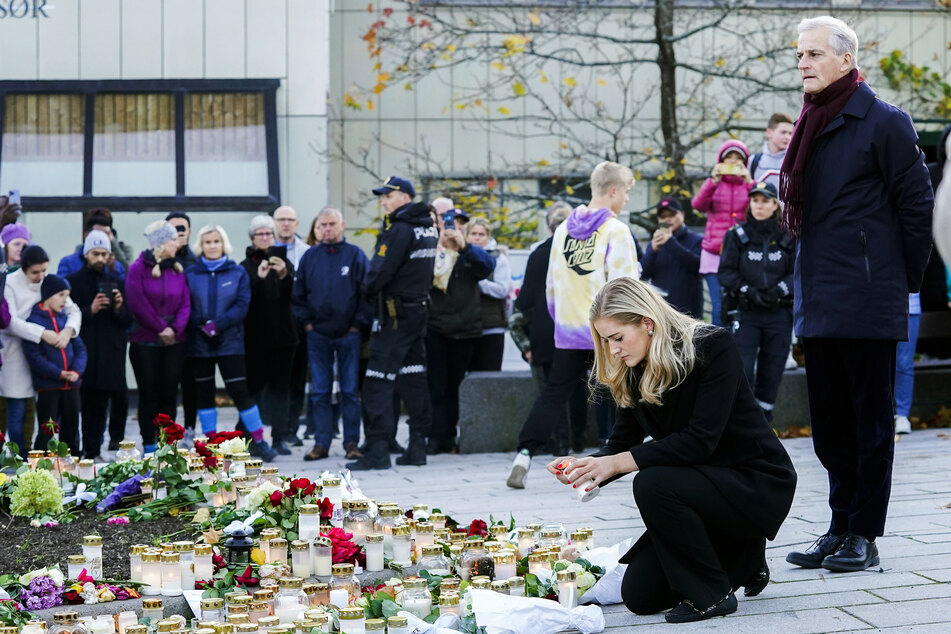 Jonas Gahr Støre (r.), Ministerpräsident von Norwegen, und Emilie Enger Mehl (2.v.r.), Justizministerin von Norwegen, legen bei ihrem Besuch in Kongsberg Blumen für die Opfer des Attentats nieder und zünden Kerzen an.
