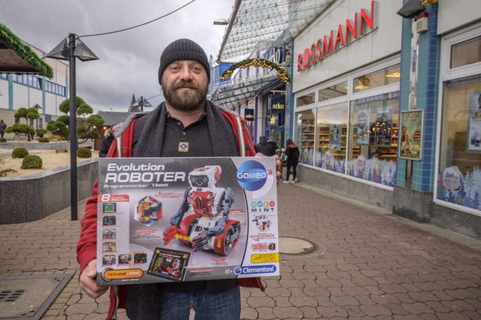 Mario Schubert (40) hält den neuen Spielzeugroboter für seinen Sohn in den Händen.