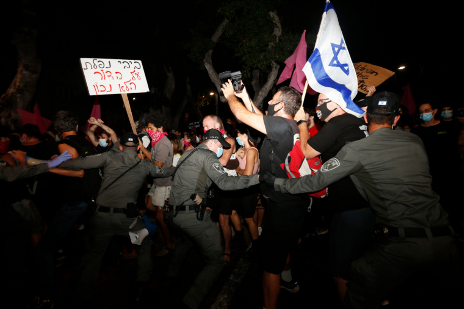 Tel Aviv: Polizisten stoßen mit Demonstranten zusammen, die trotz eines landesweiten Lockdowns aufgrund der Corona-Pandemie gegen den Premierminister Netanjahu protestieren.