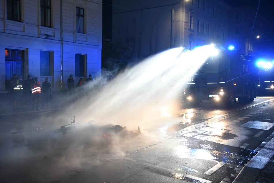 Ein Wasserwerfer beim Löschen einer Straßenbarrikade.