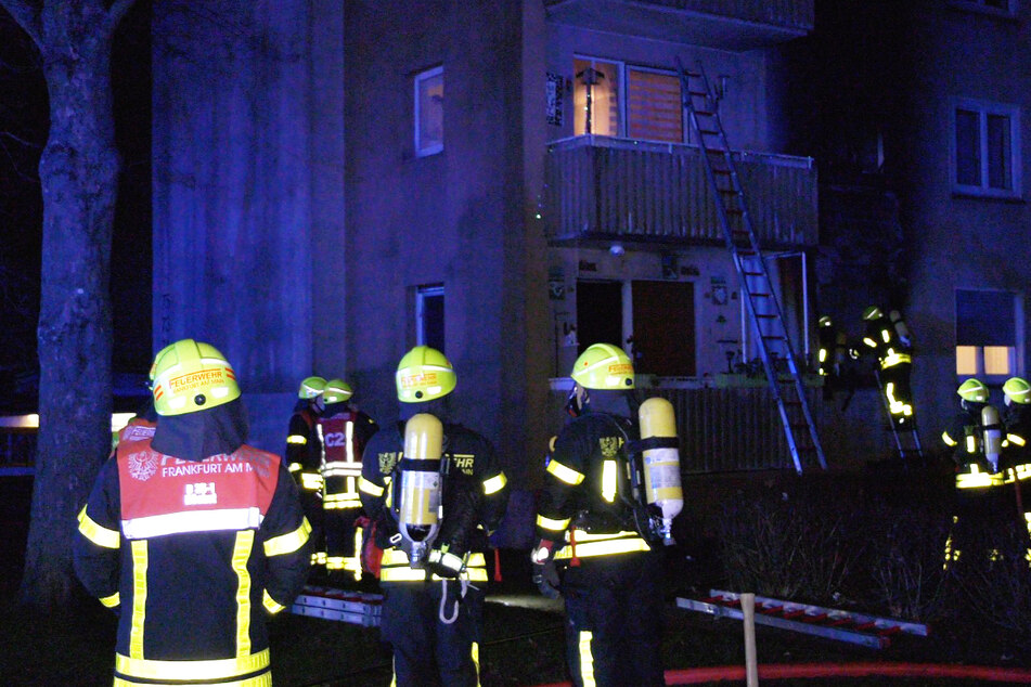 Die Feuerwehr rettet Bewohner der über der Brandwohnung liegenden Wohnung ins Freie.