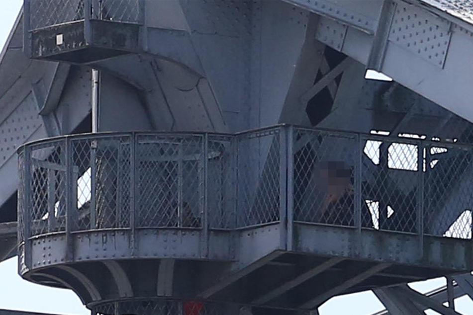 Die Frau saß auf einer Plattform in der Spitze der Brücke.