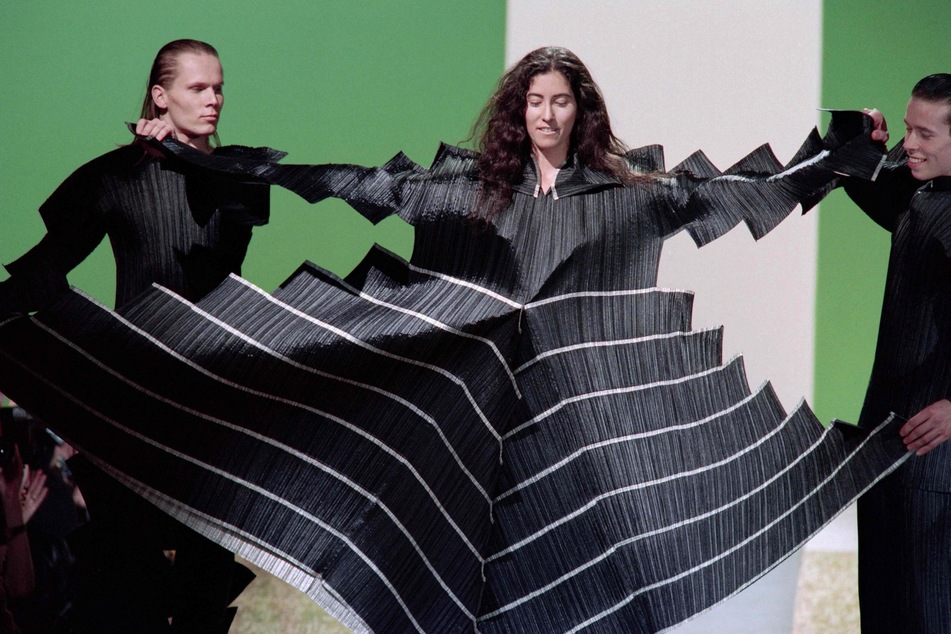 Models präsentieren ein Kleid aus der Kollektion "Pleats Please" als Teil der Issey Miyake Herbst-Winter-Kollektion 1995.