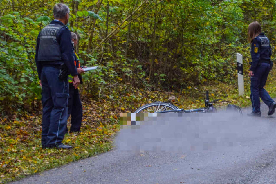 Polizisten blicken auf die Unfallstelle.