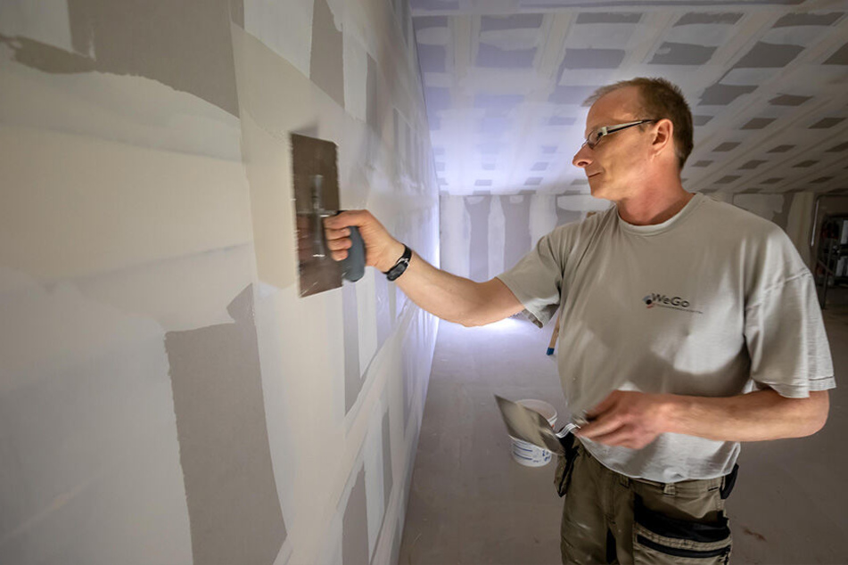 Trockenbauer Ralf Mehner (47) verspachtelt eine Wand in künftigen Lagerräumen.