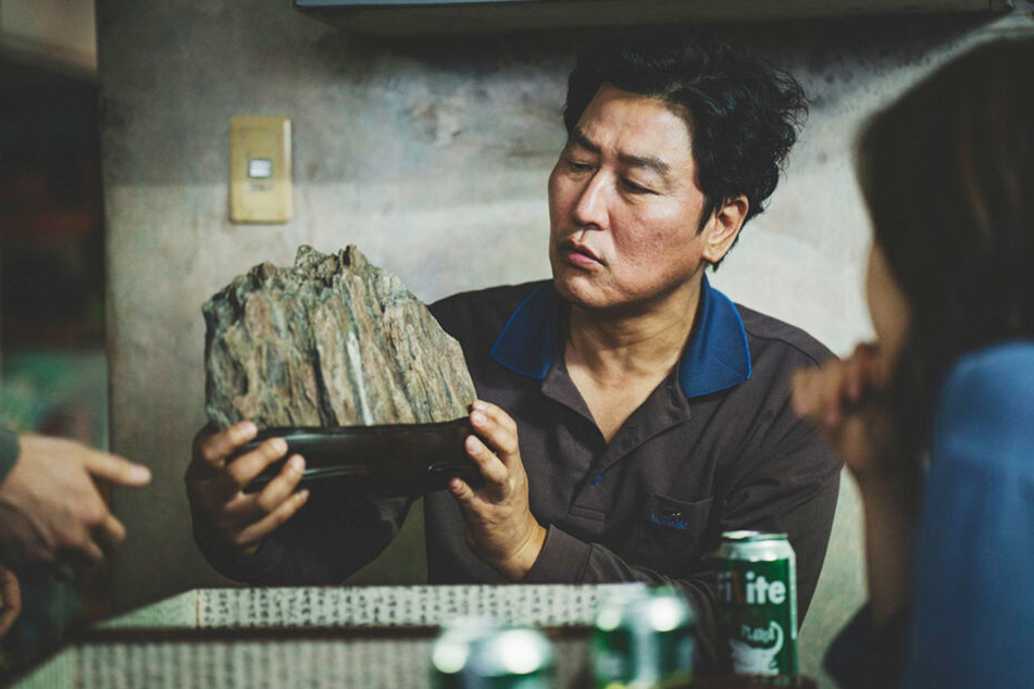 Kim Ki-taek (Kang-ho Song) betrachtet einen schönen Stein.