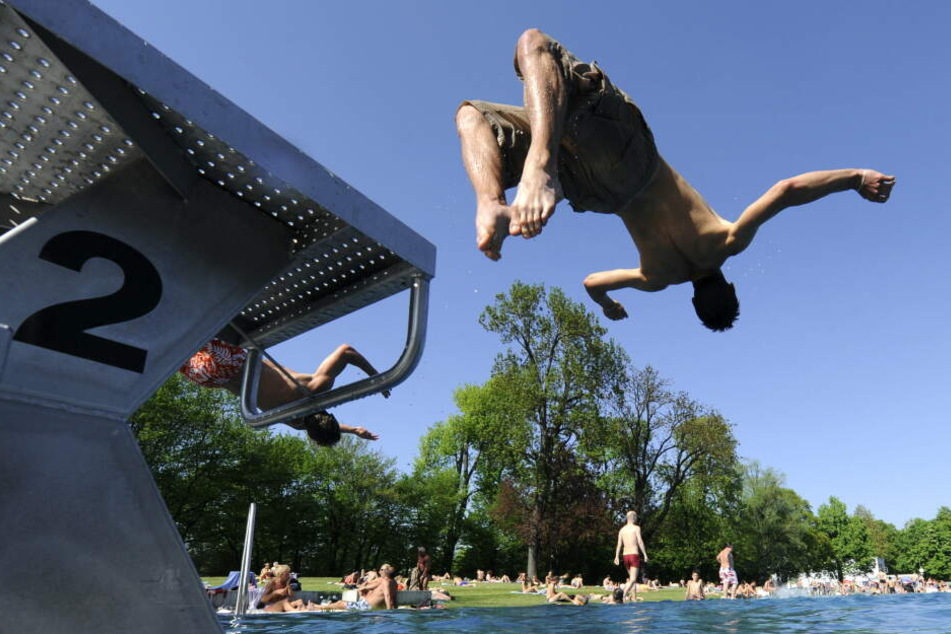Ein junger Mann springt am Freitag in München im Schyrenbad in das Becken. Das Freibad eröffnet im Mai die Badesaison. (Archivbild)