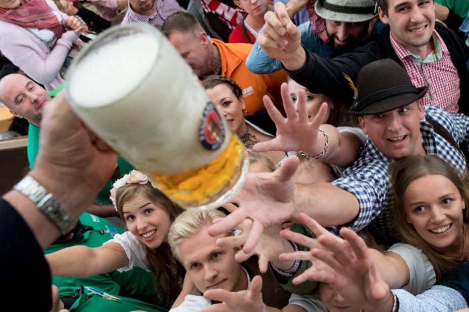 Besucher freuen sich beim Auftakt zum Oktoberfest 2017 über ihr erstes Bier.
