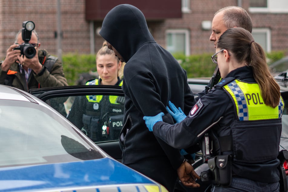 Polizisten führen einen Mann in Hamburg-Hummelsbüttel ab.