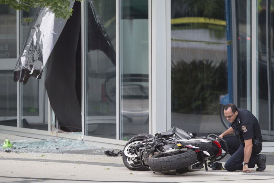 Ein Polizist untersucht das Motorrad der Stuntfrau.