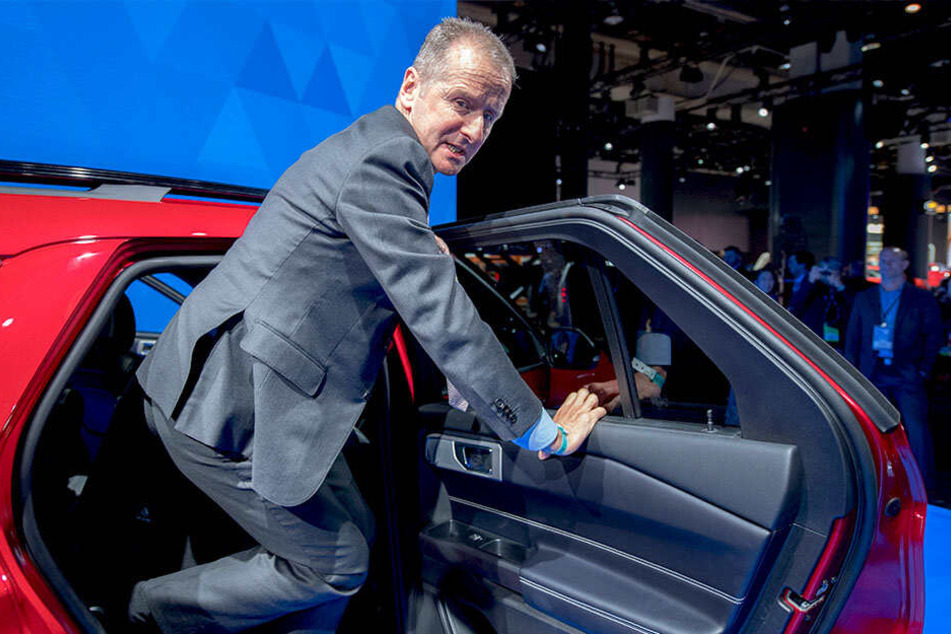 Herbert Diess (60), VW-Chef, steigt auf einer Messe aus einem Fahrzeug.