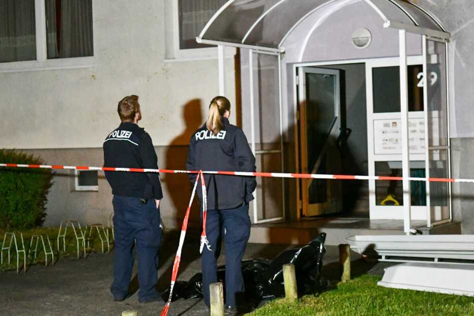 Zwei Polizisten stehen vor dem Haus in Wittenberge.