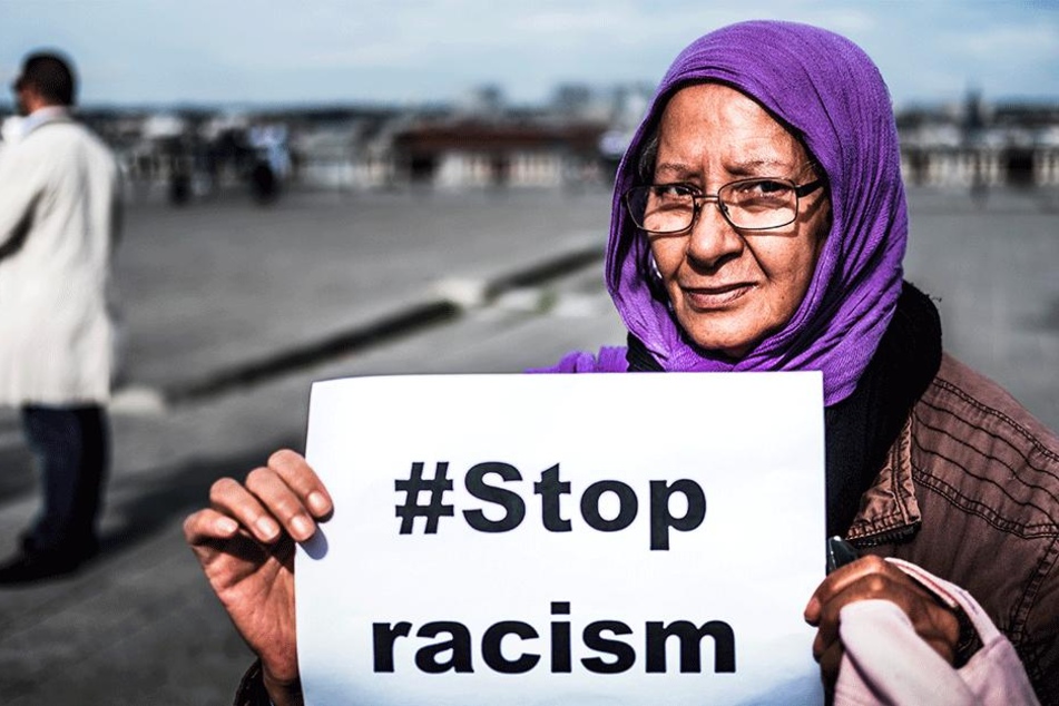 Eine Frau hält während einer Demonstration gegen Hass und Islamfeindlichkeit ein Schild mit der Aufschrift "#StopRacism" (Stoppt Rassismus) hoch (Symbolbild).