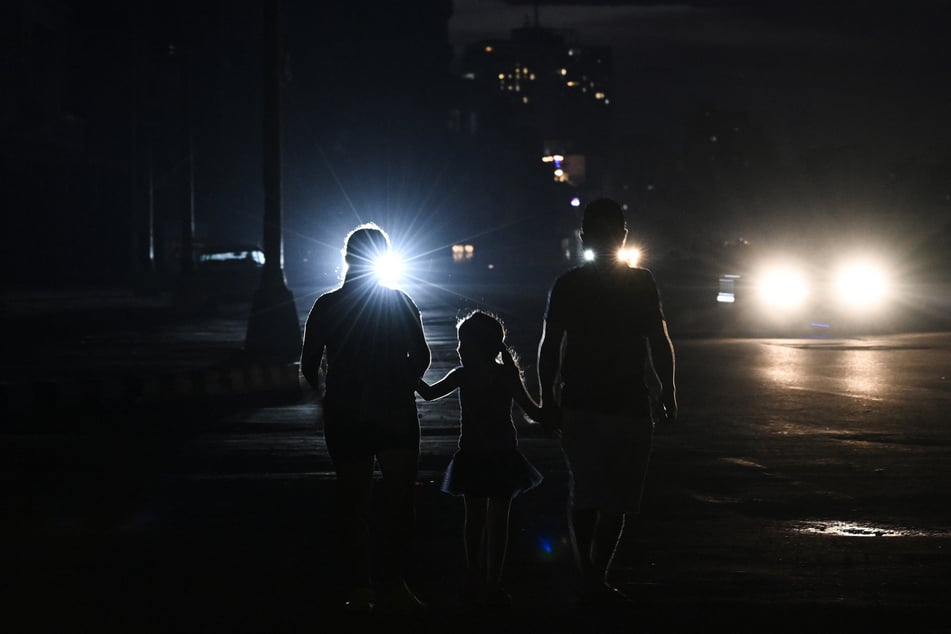 People walk along a street during a nationwide blackout in Havana, Cuba, on July 6, 2026.