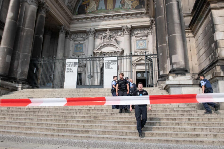 Polizisten stehen auf der Treppe des Eingangs zum Berliner Dom.