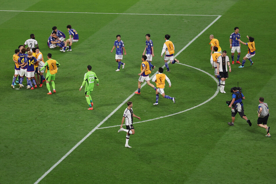 Japan players celebrate at full time after a famous win over Germany.