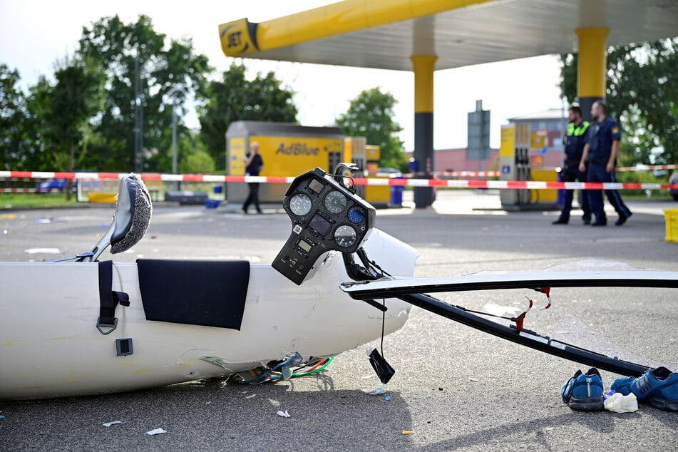 Trümmerteile des Flugzeugs liegen an der Tankstelle. Der Pilot wurde mit schweren Verletzungen ins Krankenhaus gebracht.