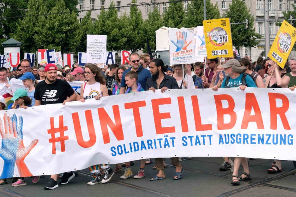 Teilnehmer einer Demonstration gegen Rassismus und Ausgrenzung, zu der das Bündnis #unteilbar aufgerufen hat, ziehen mit einem Transparent mit der Aufschrift "#unteilbar" durch die Stadt. (Archivbild)