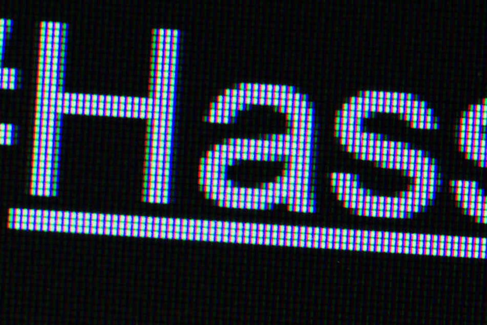 Der Hashtag "#Hass" ist auf einem Bildschirm zu sehen.