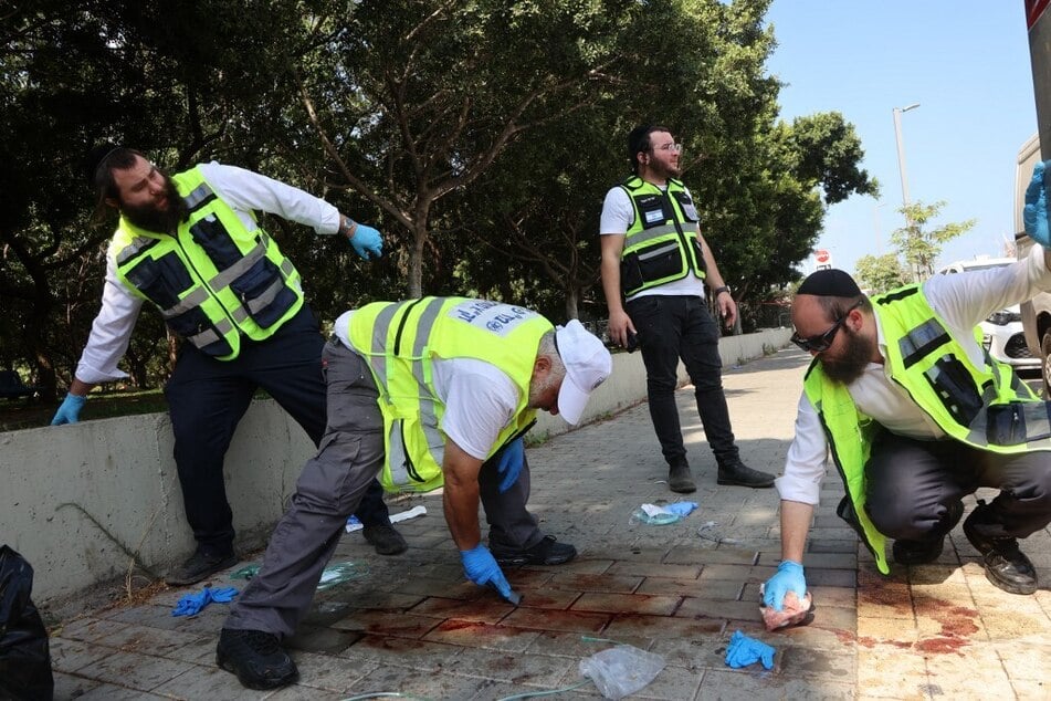 Israeli first responders wipe blood at the scene of a reported stabbing attack in Holon in the southern suburb of Tel Aviv.