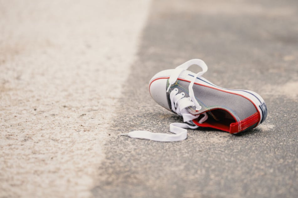 Der Schuh eines Kindes liegt auf der Straße. (Symbolfoto)