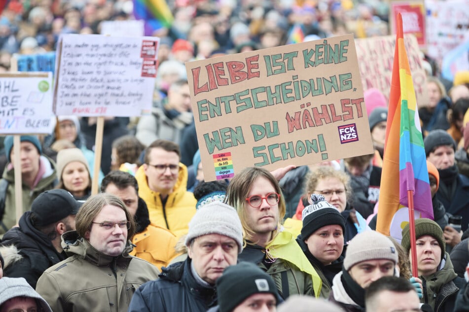 Teilnehmer der Demo halten ein Schild mit der Aufschrift "Liebe ist keine Entscheidung, wen Du wählst, schon!" hoch.