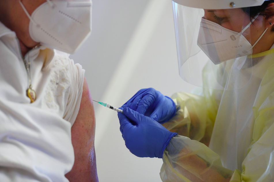 Eine Bewohnerin eines Altersheims (l) wird von einer Mitarbeiterin eines mobilen Impfteams im Altersheim mit dem Impfstoff von Pfizer/Biontech gegen das Coronavirus geimpft.
